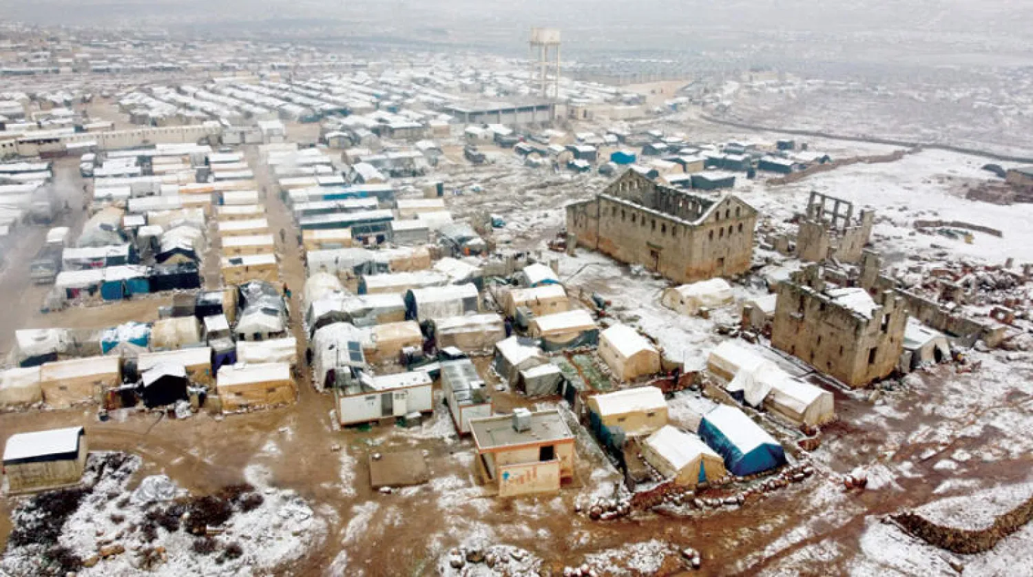 ثلوج تغطي مخيماً للنازحين قرب منطقة أثرية في شمال غربي سوريا في 23 الشهر الجاري (أ.ف.ب)