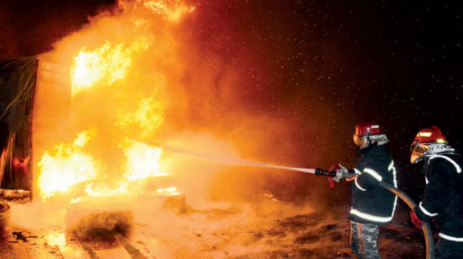 إطفائيون يحاولون إخماد حريق اندلع إثر قصف إسرائيلي استهدف ميناء اللاذقية غرب سوريا في 28 ديسمبر الماضي (سانا - إ.ب.أ)