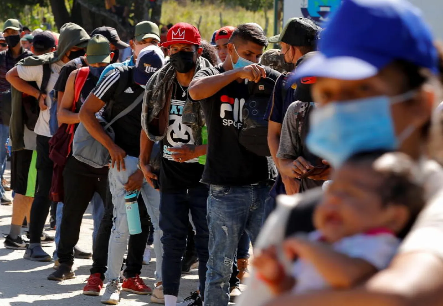 مهاجرون من أميركا الوسطى يصطفون للعبور إلى الجانب الأميركي من الحدود (رويترز)