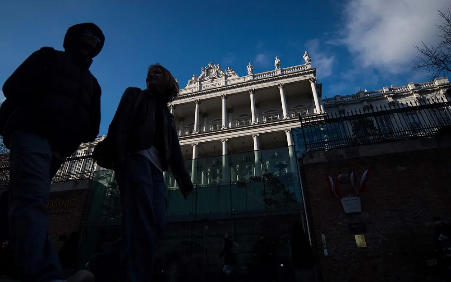 People walk past Palais Coburg, where closed-door nuclear talks take place in Vienna, Austria, December 17, 2021. (AP)