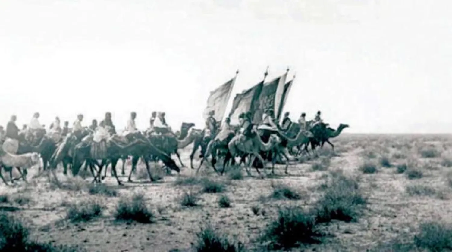 Saudi soldiers carry the Saudi flag and banners during the reign of King Abdulaziz in 1911. (Photo courtesy of Adnan al-Turaif to Asharq Al-Awsat)