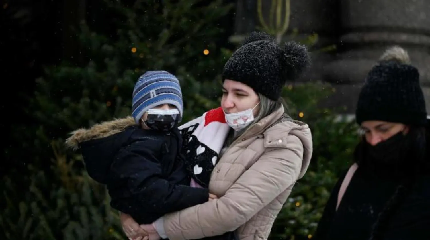 Moskova'da bir sokakta maske takan iki kadın ve bir çocuk (AFP)