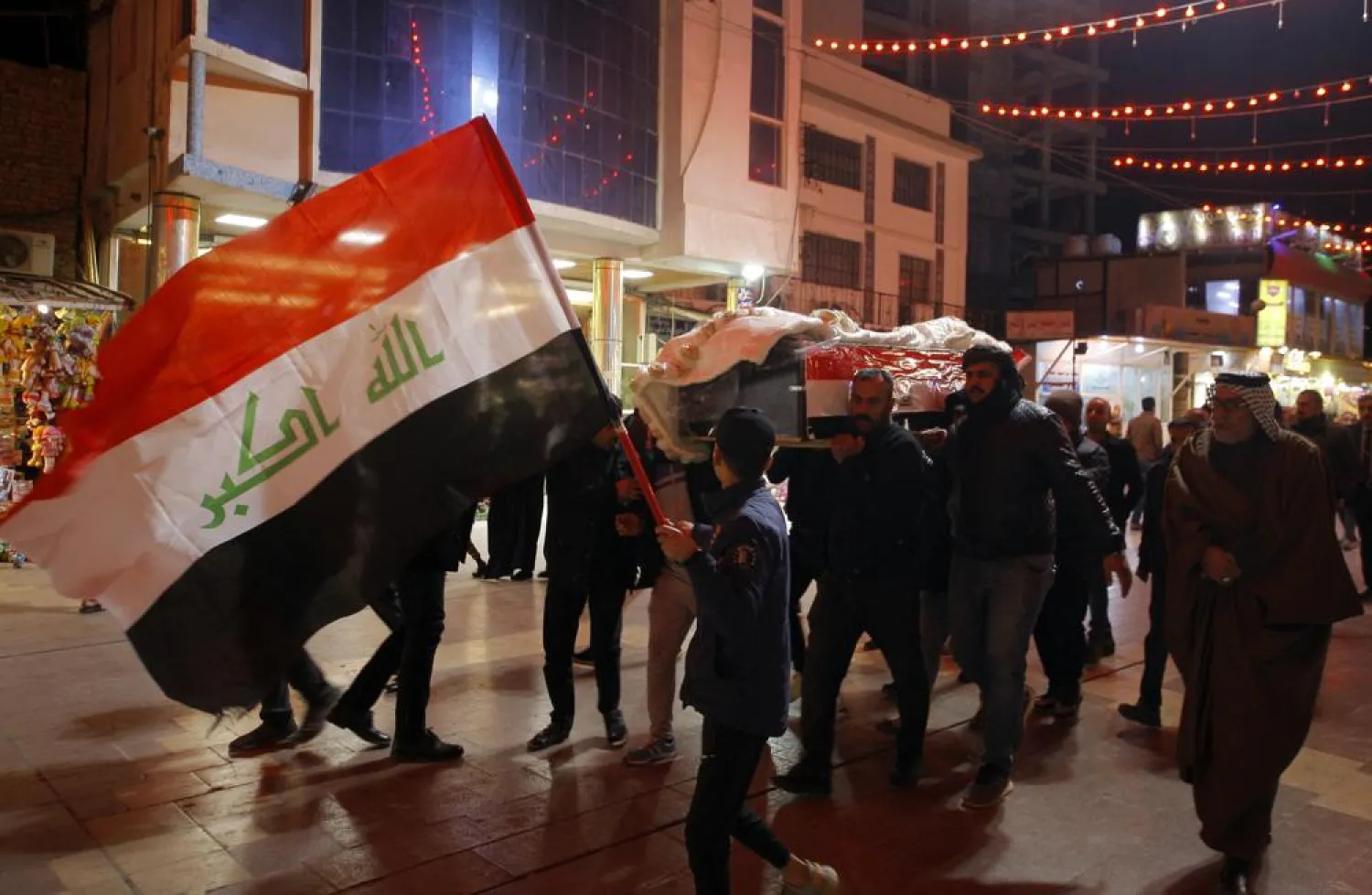 Mourners carry the flag-draped coffins of Iraqi soldiers killed in an attack by gunmen of the ISIS extremist group in Baqouba in Diyala province, Iraqi, Friday, Jan. 21, 2022. (AP Photo/Anmar Khalil)
