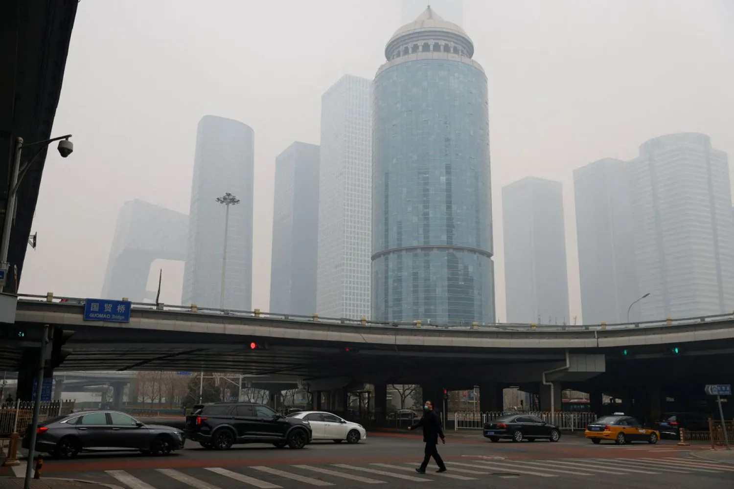 A man wearing face mask walks on the street during a day with polluted air, following the outbreak of the coronavirus disease (COVID-19), in Beijing, China February 13, 2021. (Reuters)