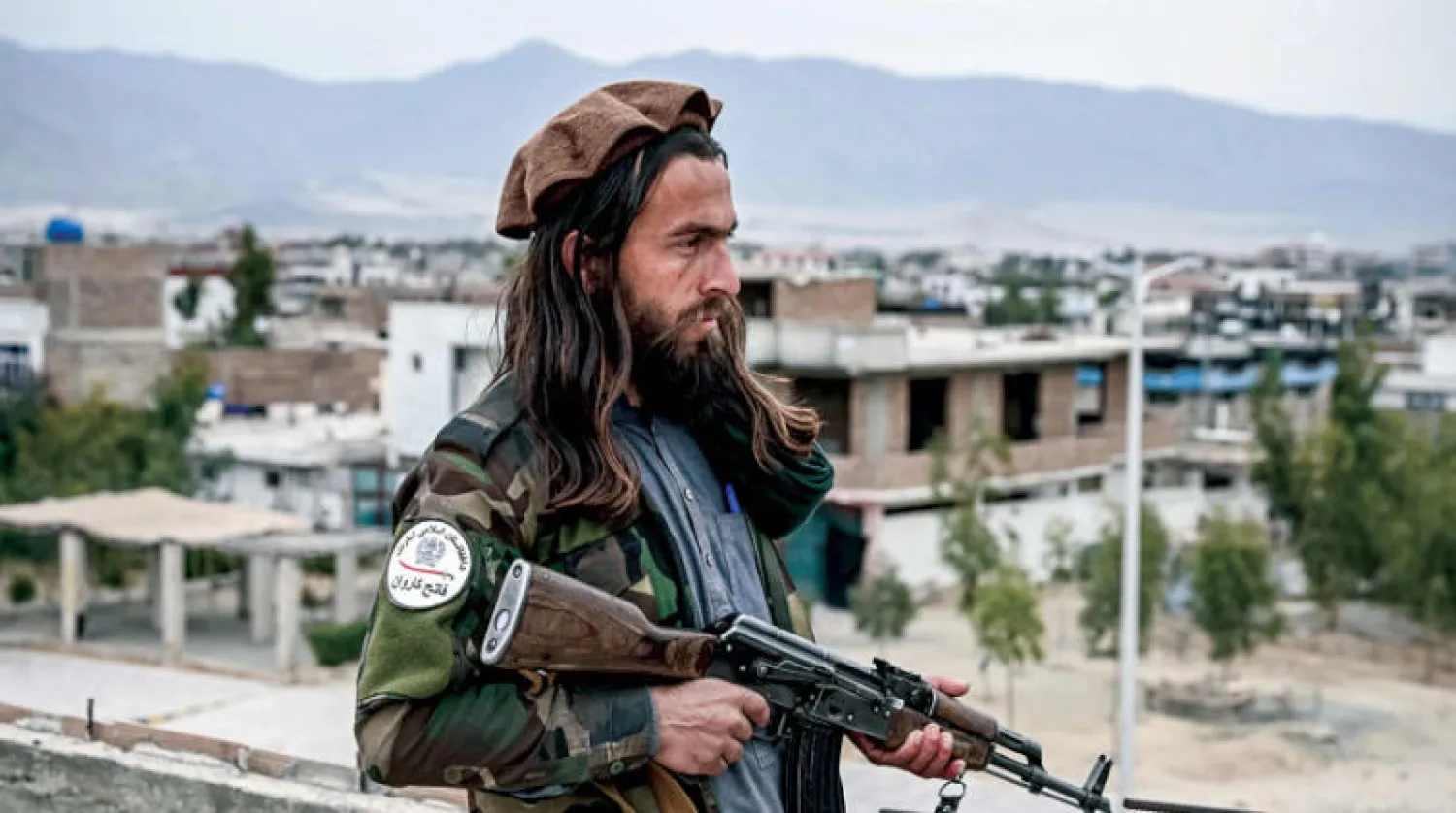 أحد عناصر «طالبان» يقف حارساً أمام جامعة «لغمان» في شرق البلاد (أ.ف.ب)