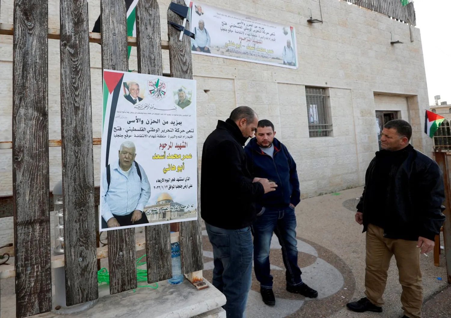 Men stand next to a poster of Palestinian Omar Abdalmajeed As'ad, in Jiljilya village in the Israeli-occupied West Bank, January 12, 2022. (Reuters)