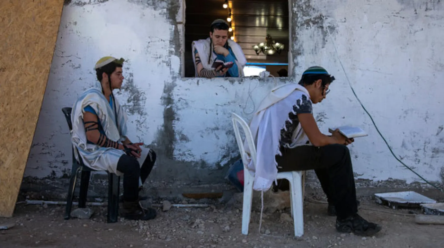 مستوطنون يصلُّون في بؤرة «إفيتار» في الضفة الغربية يونيو الماضي (أ.ب)