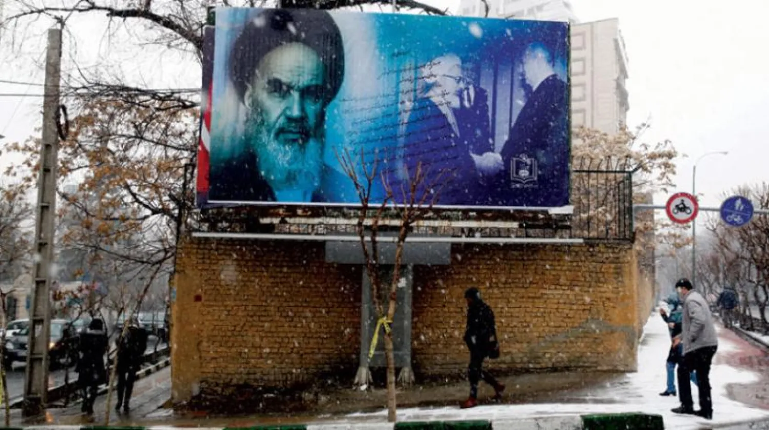 Iranians pass by a poster of Khomeini in Tehran. (EPA)