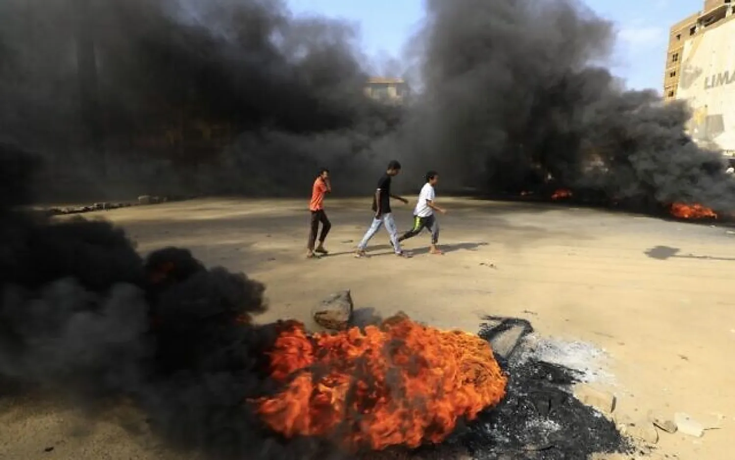 Sudanese protesters burn tires to block a road in Khartoum (File photo: AFP)
