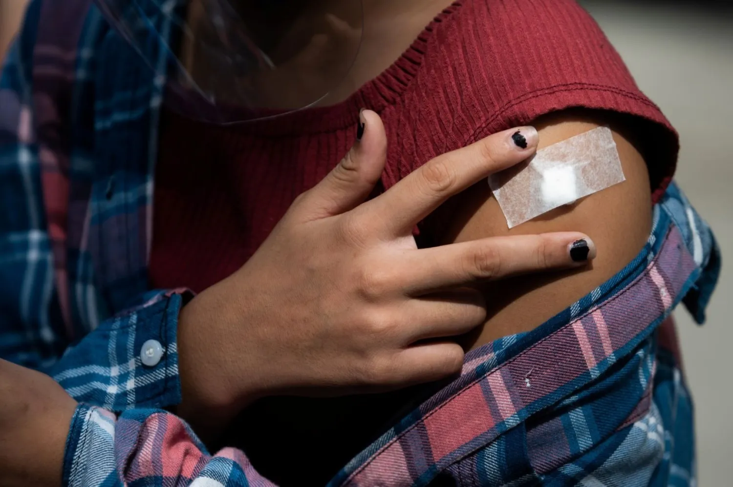 A child shows her adhesive bandage after being inoculated with Pfizer-BioNTech vaccine against the coronavirus disease (COVID-19), during the vaccine rollout for children with comorbidities, in Pasig, Metro Manila, Philippines, October 15, 2021. REUTERS/Lisa Marie David