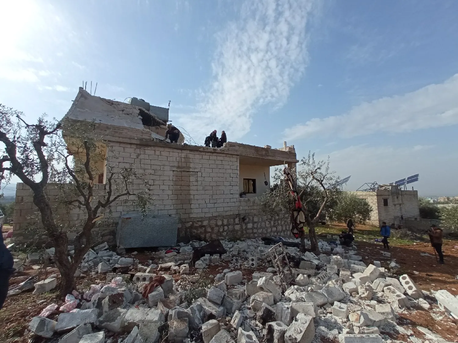 أشخاص يقفون فوق منزل متضرر من الغارة (الشرق الأوسط)