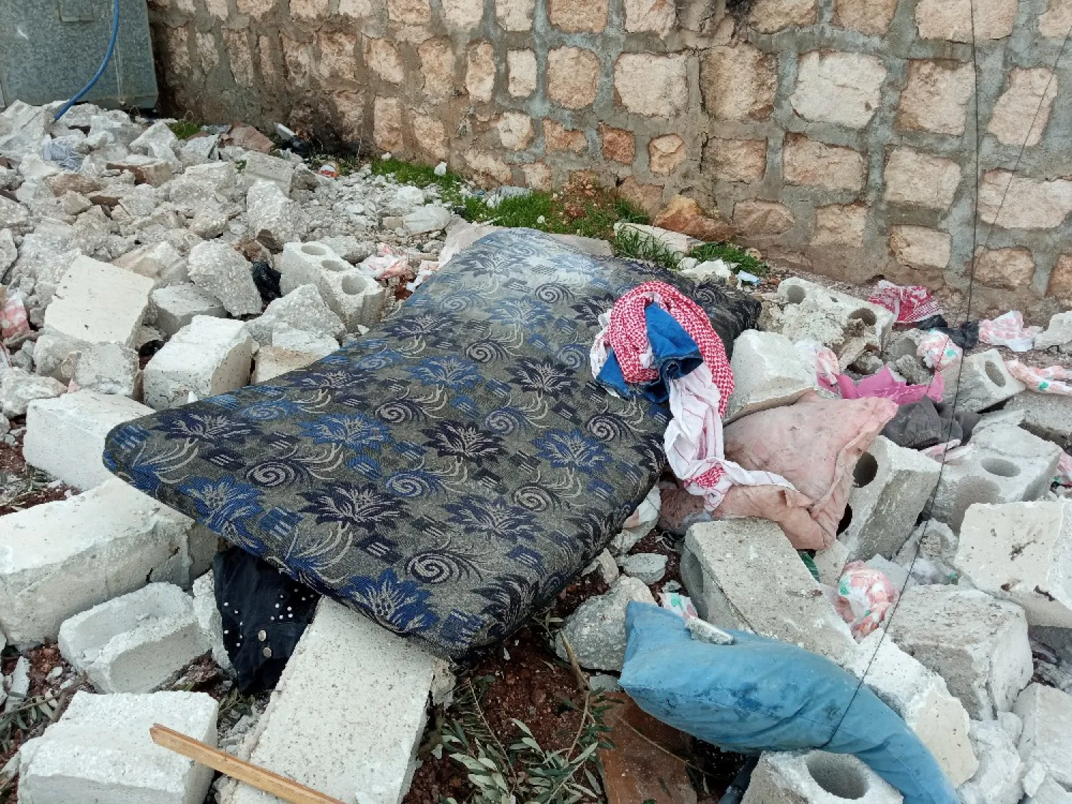 بقايا فِراش أحد الأسر المتضررة من الغارة الأميركية في ساحة منزلهم بالقرب من بلدة اطمة (الشرق الأوسط)