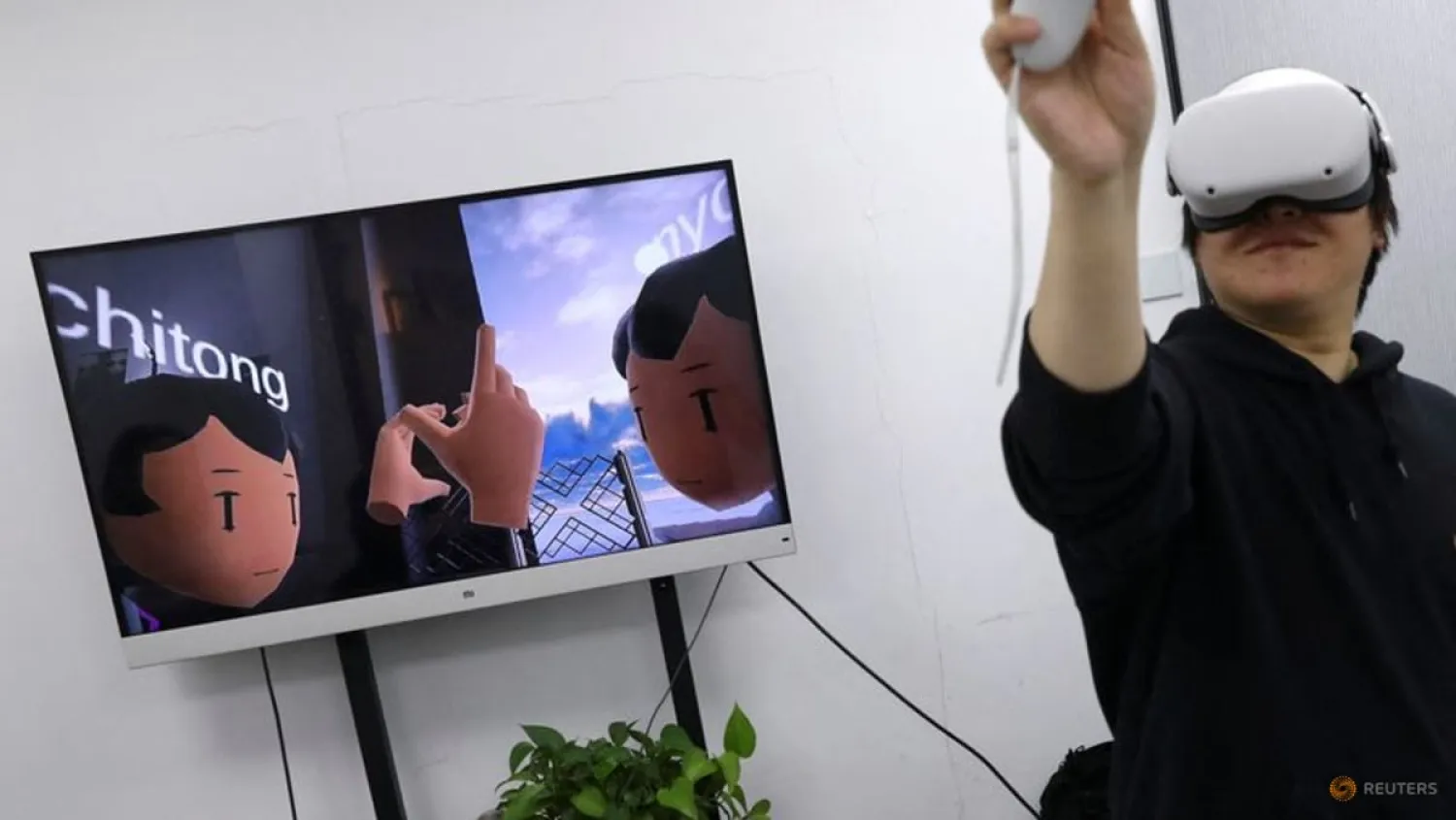 (L) Pan Bohang, founder of vHome, a virtual reality (VR) social gaming platform, wearing Meta's Oculus VR headset speaks with a user during a virtual gathering, at an office in Beijing, China January 21, 2022. Picture taken January 21, 2022. REUTERS/Tingshu Wang/File Photo


