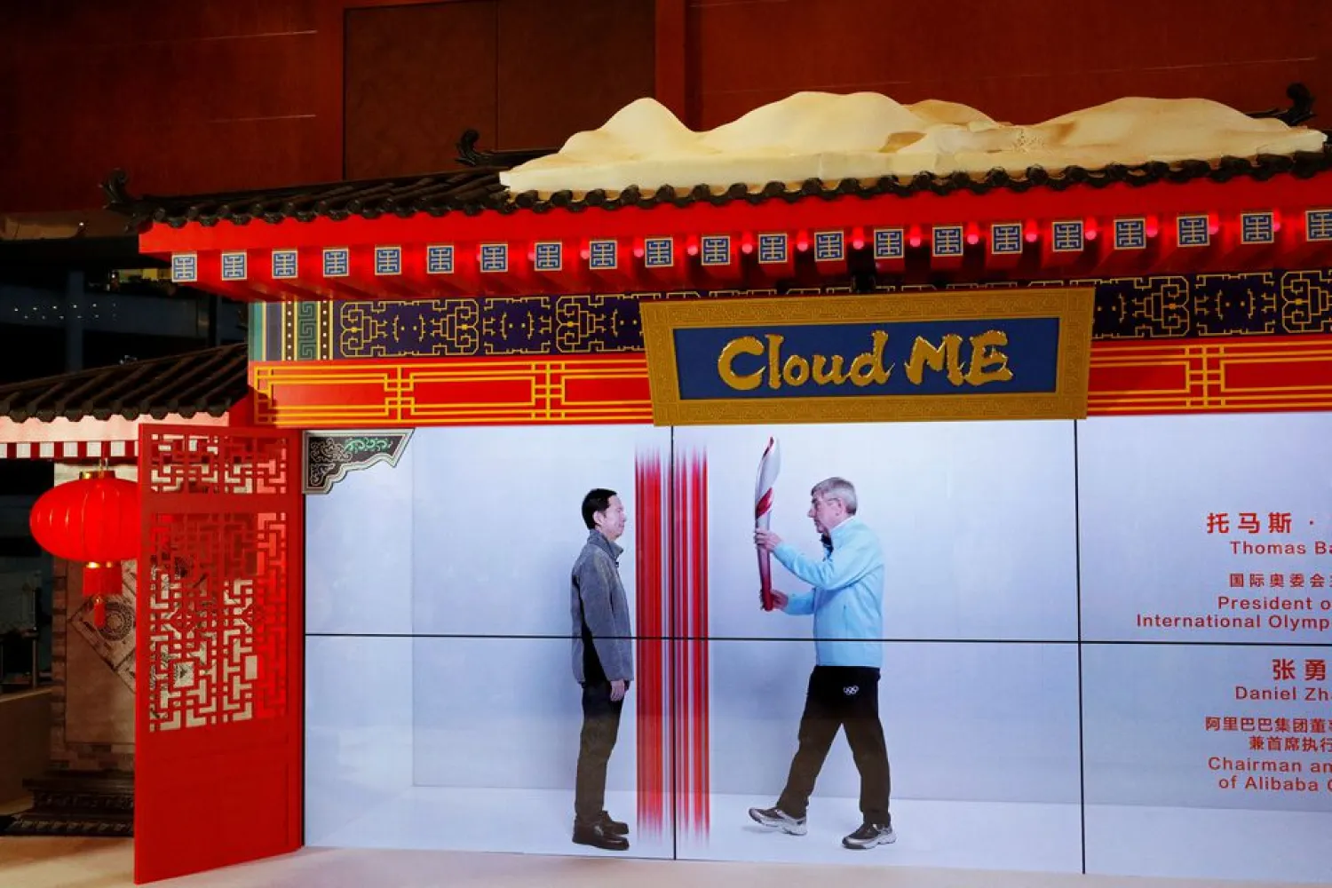 A hologram of International Olympic Committee (IOC) President Thomas Bach hands an Olympic torch to a hologram of Alibaba Group Chairman and Chief Executive Officer Daniel Zhang, at an event demonstrating Alibaba's Cloud ME technology in Beijing, China, February 6, 2022. (Reuters)
