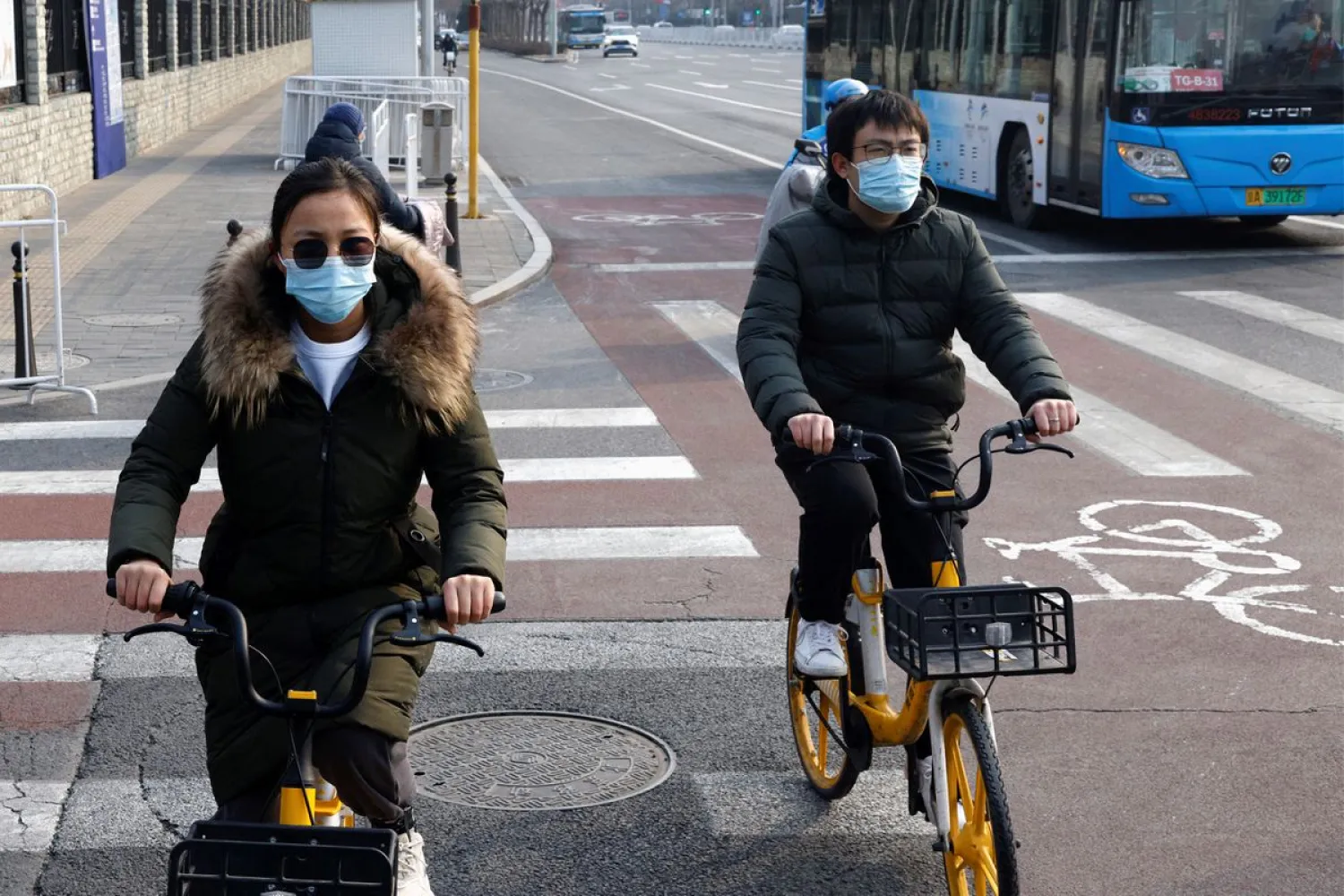 People wearing protective masks ride bicycles, as the coronavirus disease (COVID-19) pandemic continues, in Beijing, China January 30, 2022. (Reuters)