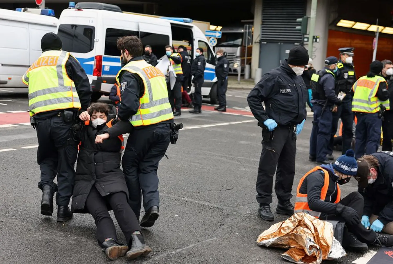 Police officers drag a "Letzte Generation" (Last Generation) activist during a protest against food waste and for an agricultural change to reduce greenhouse gas emissions, in Berlin, Germany, February 7, 2022. (Reuters)