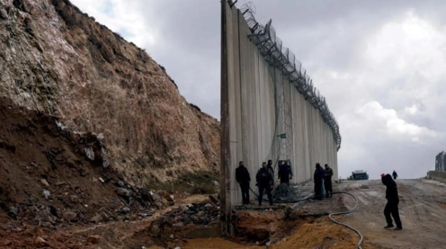Teams work to reconstruct the collapsed section of the wall. (AP)