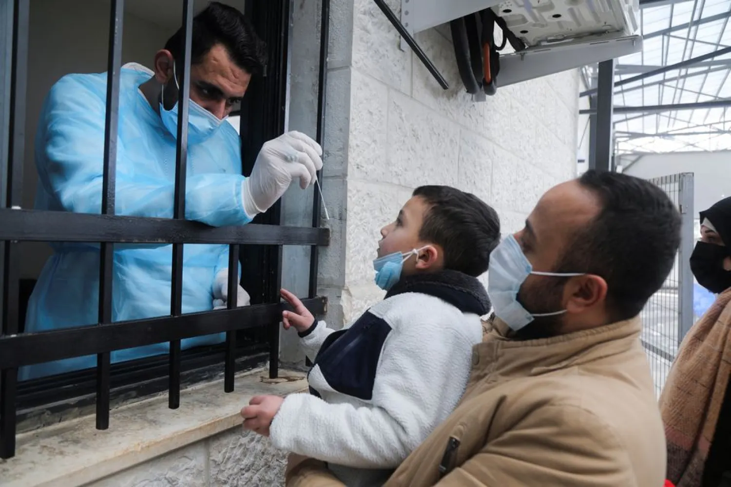 A Palestinian child looks at a swab before being tested for the coronavirus disease (COVID-19), in light of the outbreak, in Nablus the Israeli-occupied West Bank, February 7, 2022. (Reuters)