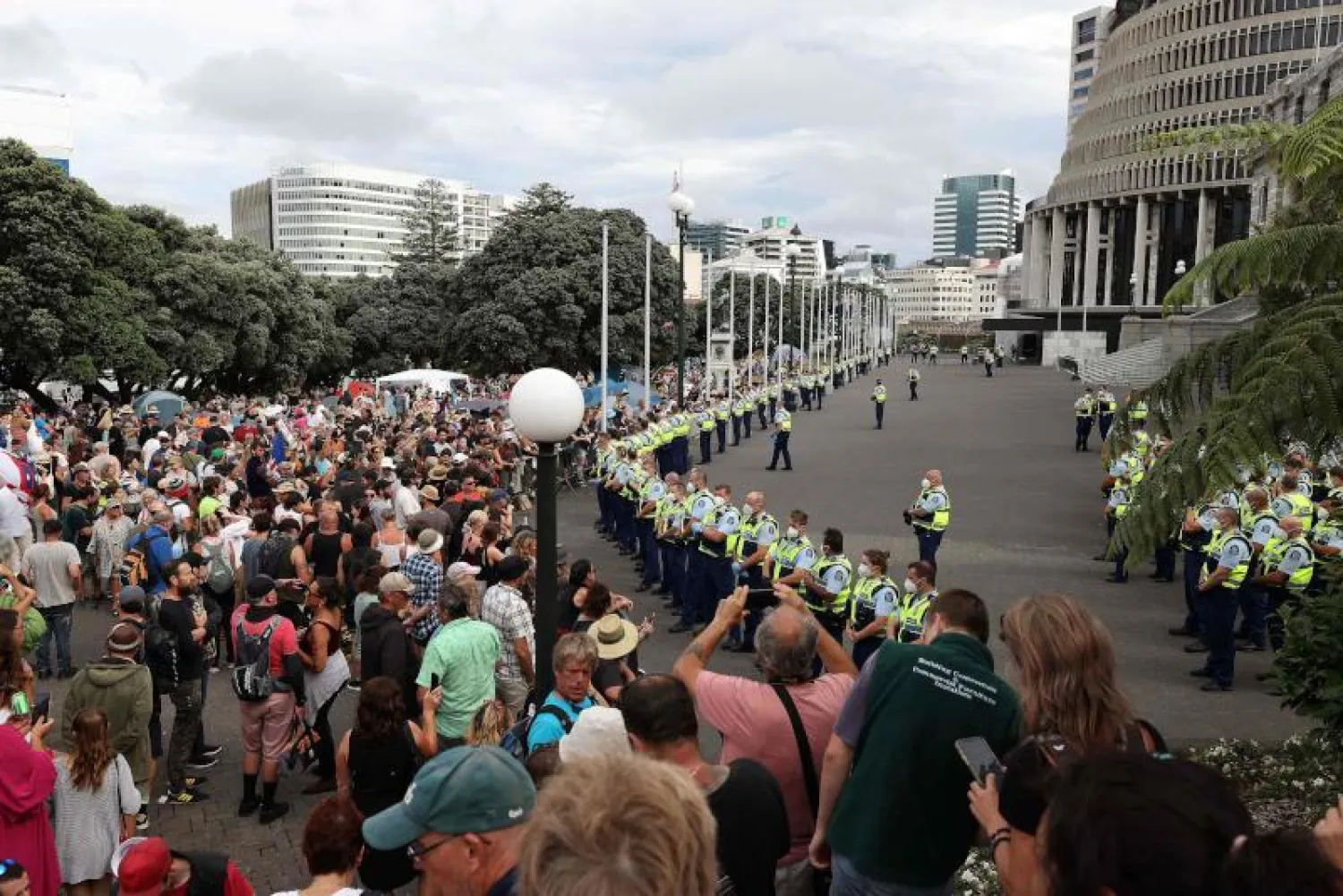 الشرطة والمتظاهرون ضد قيود «كورونا» أمام مبنى البرلمان في ولنغتون (أ.ف.ب)