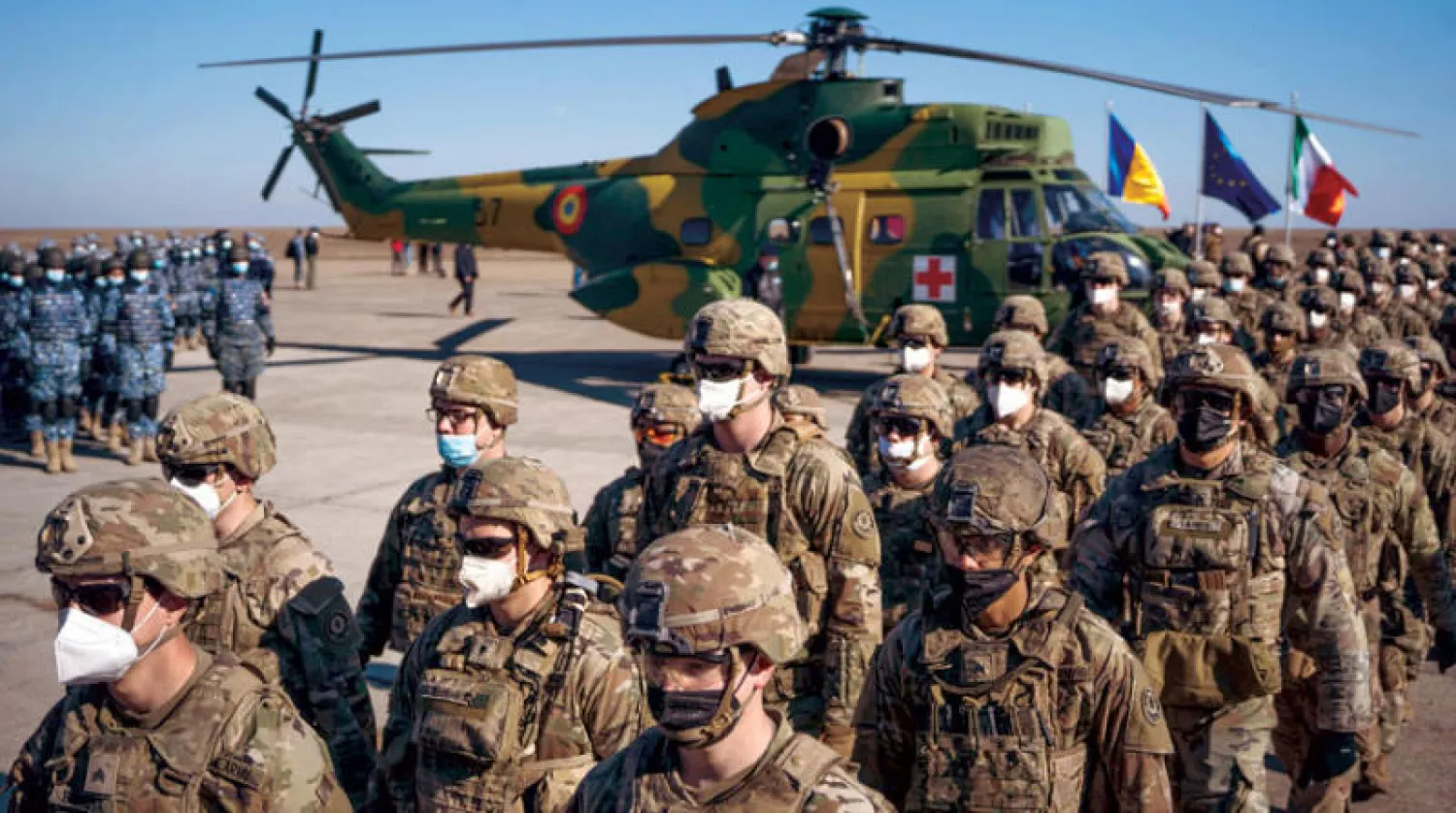 جنود أميركيون وآخرون من دول أخرى في «الناتو» في قاعدة ميخائيل كوغالنيسينو برومانيا خلال زيارة الأمين العام للحلف إلى القاعدة أمس (أ.ف.ب)