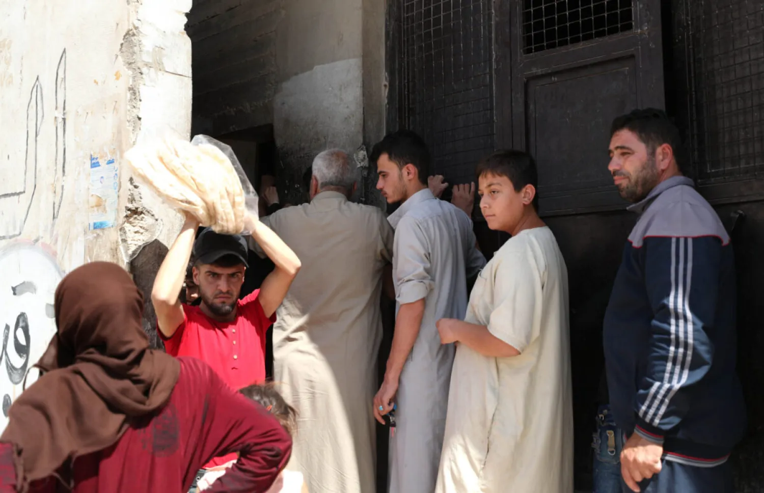 Syrians buy bread at a shop in the town of Binnish in the country's northwestern Idlib province on June 9, 2020. [OMAR HAJ KADOUR/AFP via Getty Images]
