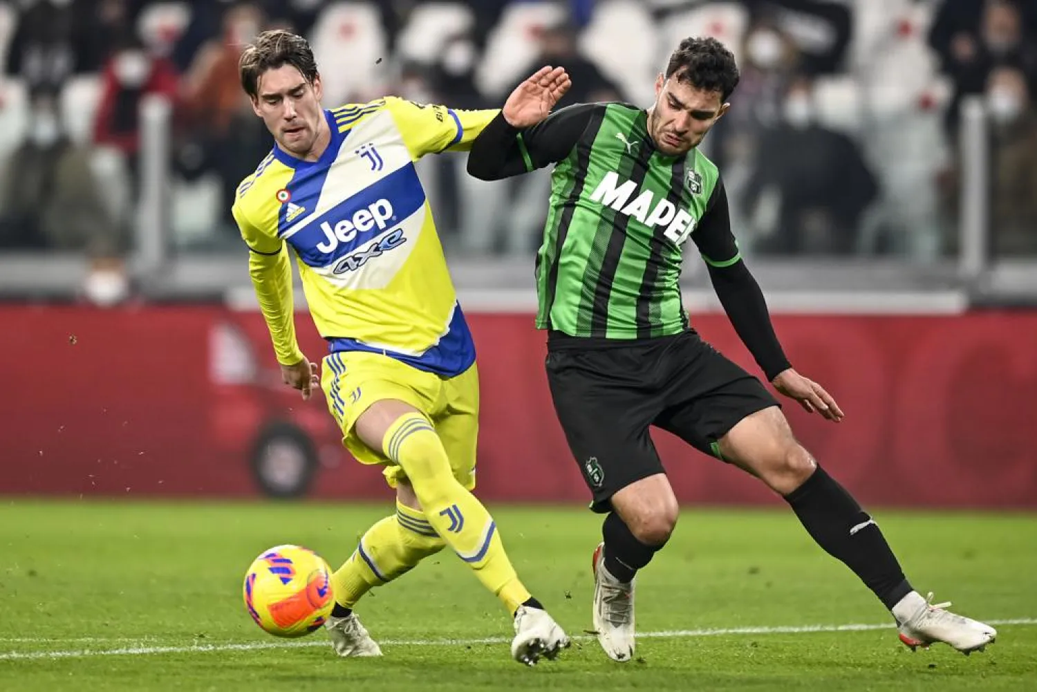 Juventus' Dusan Vlahovic, left, and Sassuolo's Kaan Ayhan battle for the ball during the Italian Coppa Italia match between Juventus and Sassuolo at the Allianz Stadium in Torino, Italy, Thursday, Feb. 10, 2022. (AP)