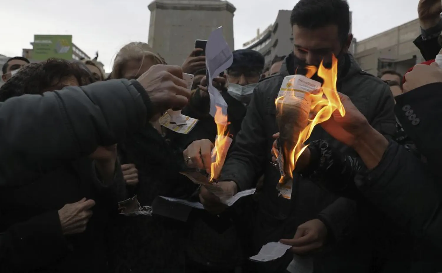 Members of Turkey's main opposition Republican People's Party burn invoices as they gather in front of a monument of the founder of modern Turkey, Mustafa Kemal Ataturk, in Ankara, Turkey, Wednesday, Feb. 9, 2022, to protest high electricity prices, as people set on fire electricity bills they say they can't pay. (AP)