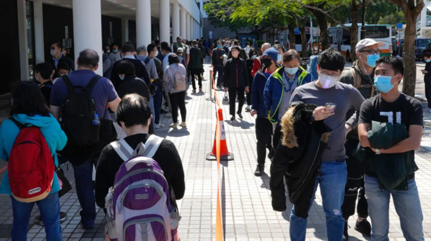 طوابير من المواطنين في انتظار الخضوع لفحص الكشف عن الإصابة بـ«كوفيد – 19» في هونغ كونغ أمس (أ.ب)