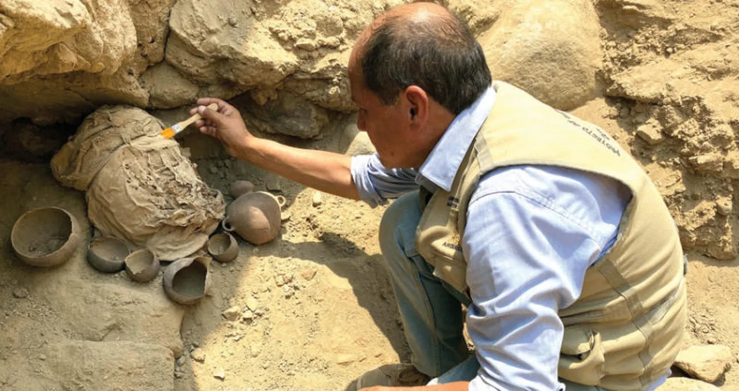 عالم آثار ينقب لاستعادة بقايا واحدة من 14 مومياء في بيرو (رويترز)