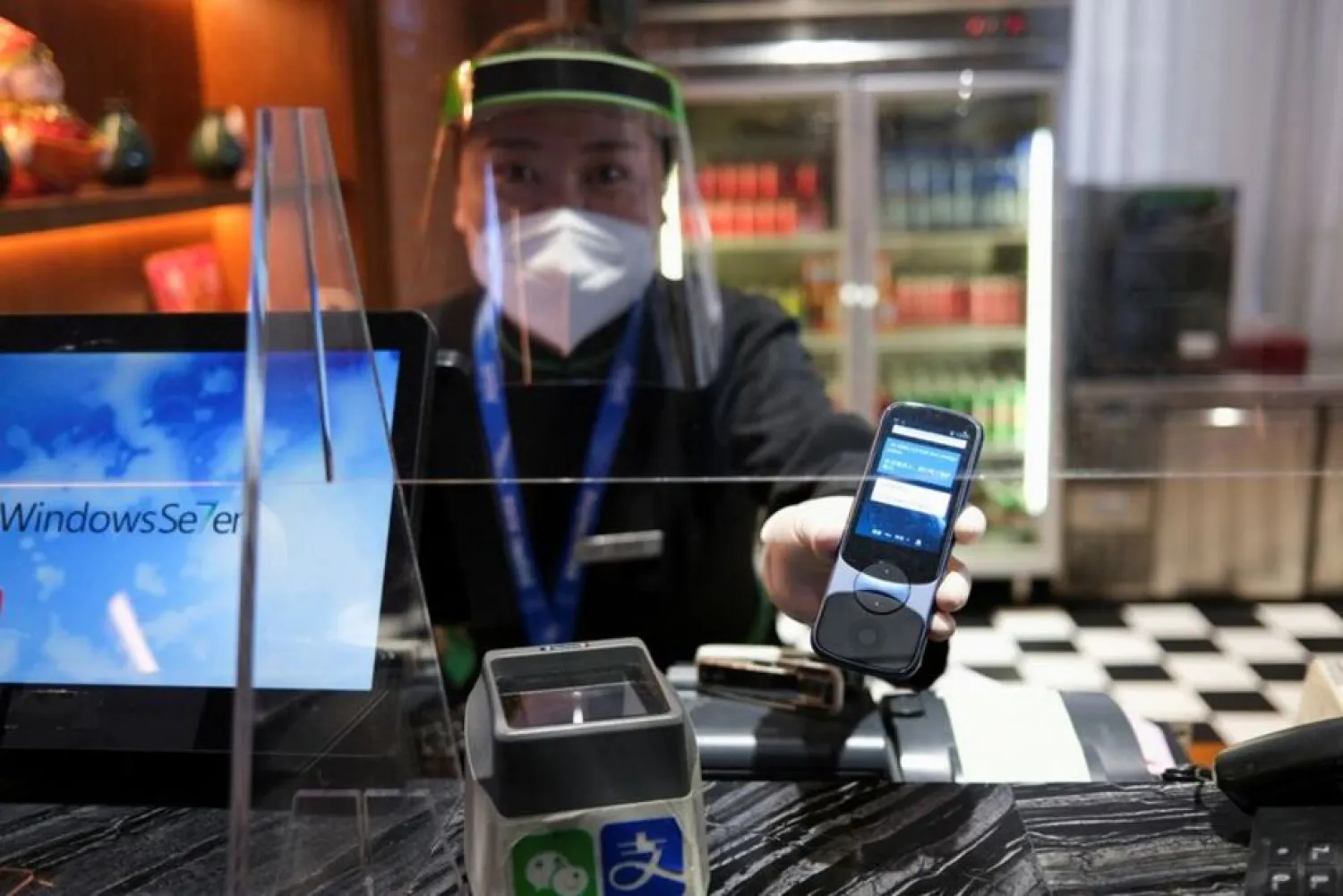 A Chinese server holds a translation device, used to communicate with foreign guests, at the Green Dragon restaurant inside the Olympics closed loop in Zhangjiakou, China, February 14, 2022. (Reuters)