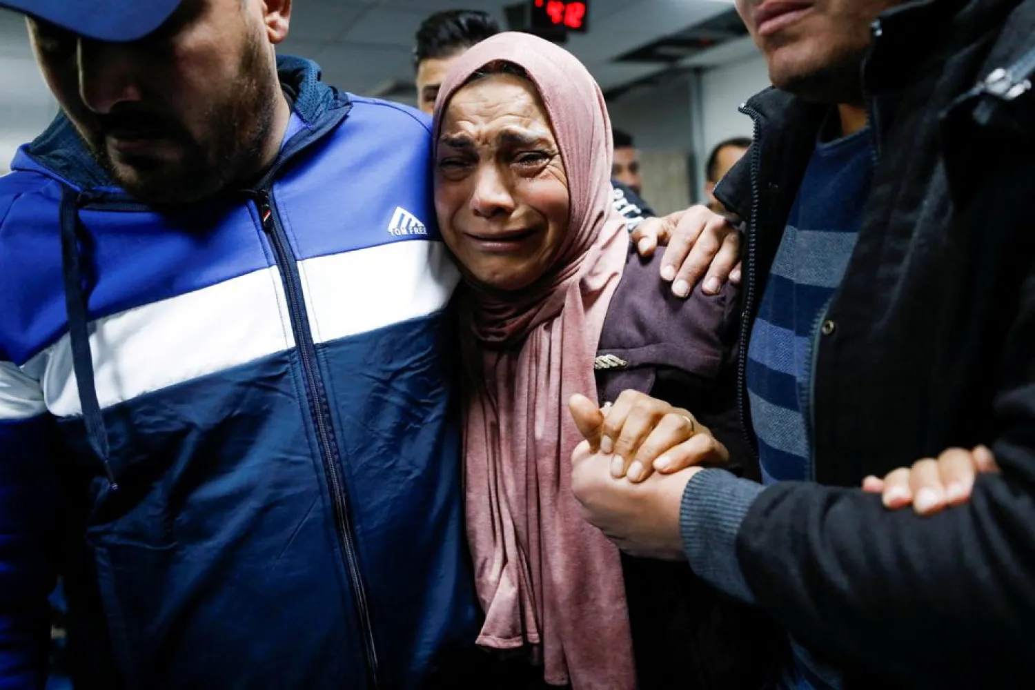 A mother of a Palestinian cries next to his body (not pictured), who medics said was shot by Israeli forces during clashes, at a hospital near Ramallah in the Israeli-occupied West Bank February 15, 2022. (Reuters)