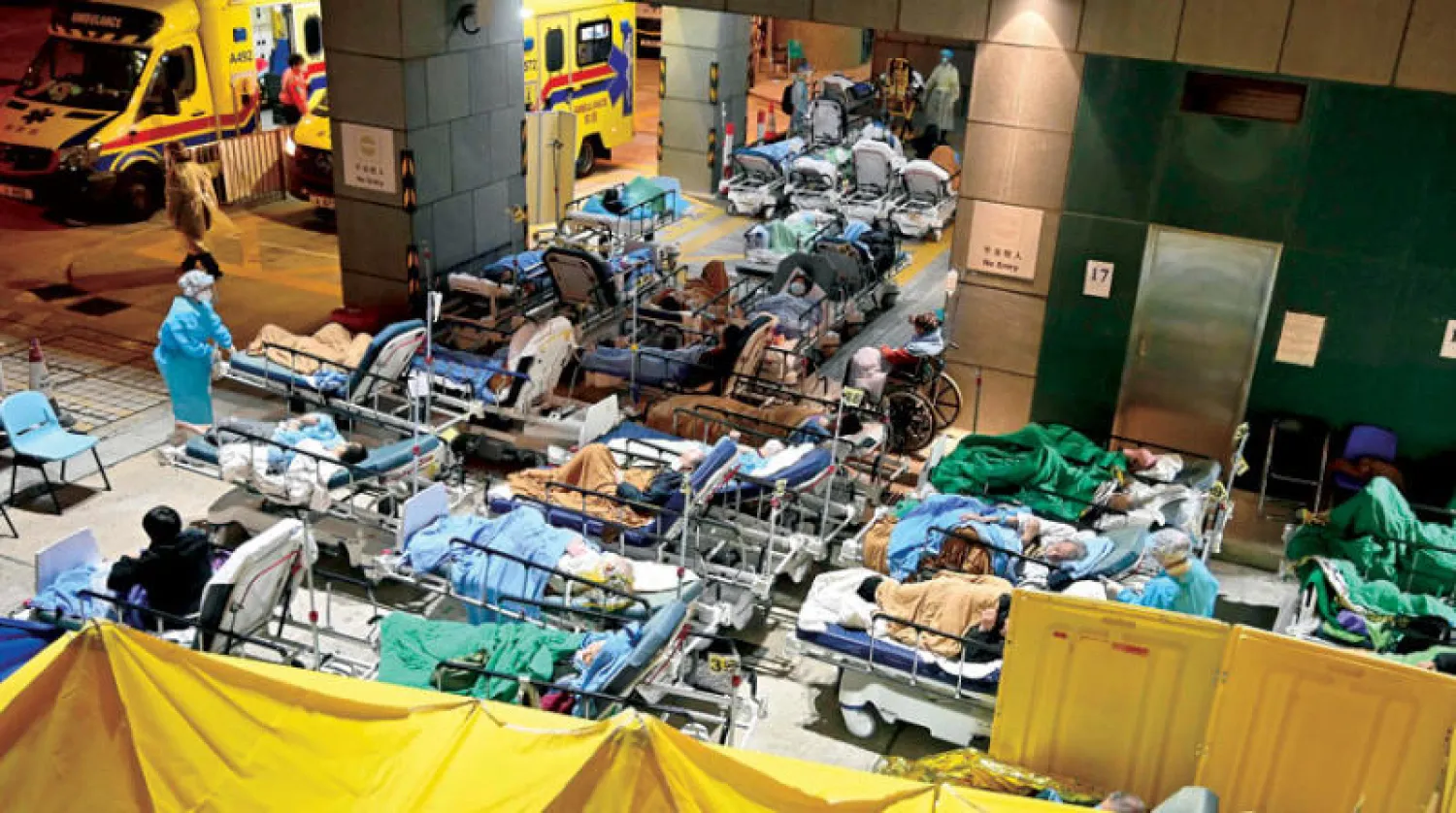 مصابون بـ«كورونا» يتلقون العلاج خارج مركز «كاريتاس» الطبي في هونغ كونغ أمس (أ.ف.ب)