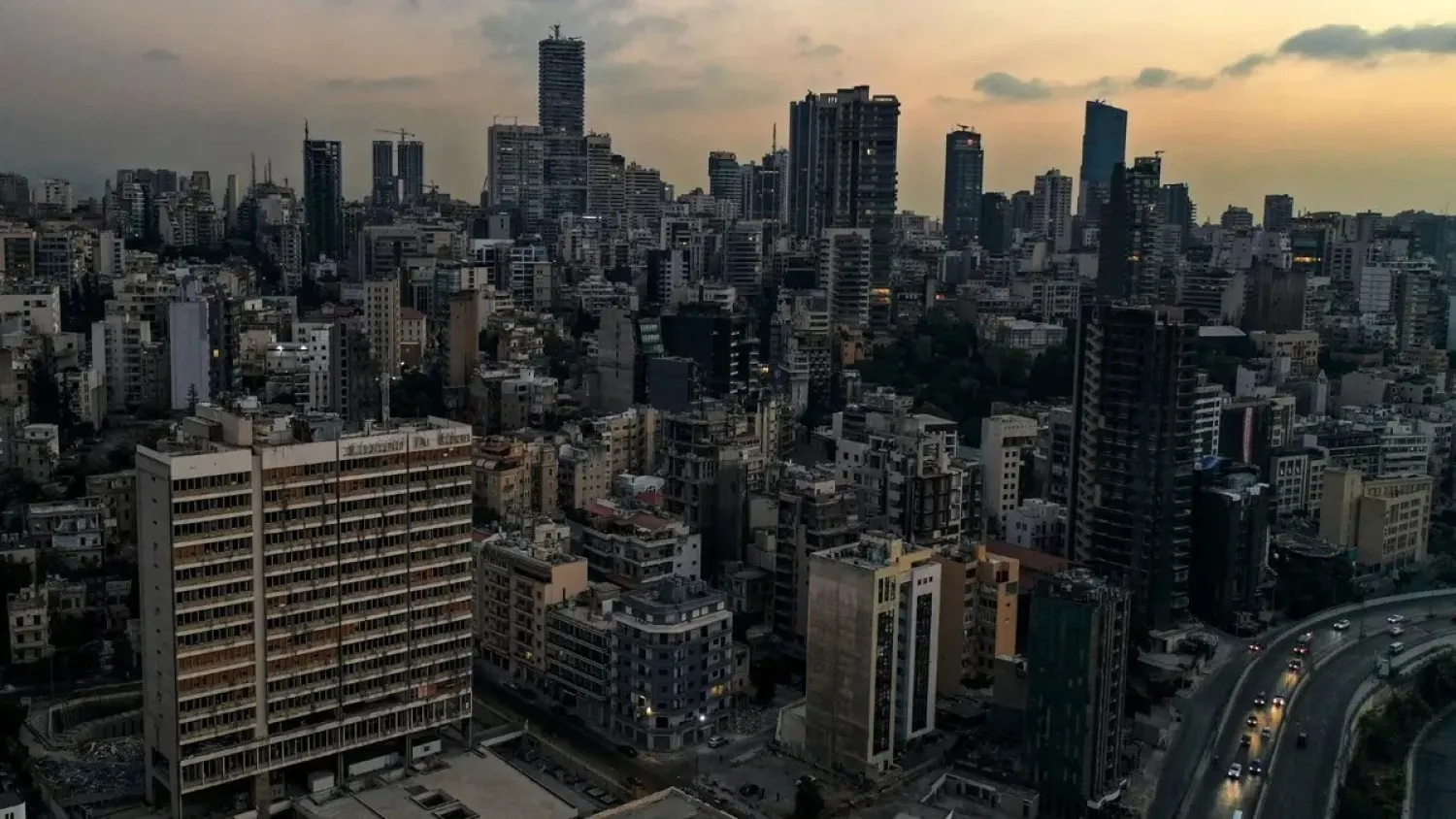 This picture taken on October 11, 2021 shows a sunset aerial view of the (L) Électricité du Liban (Electricity of Lebanon or EDL) building in Lebanon's capital Beirut, in darkness during a power outage. (AFP)