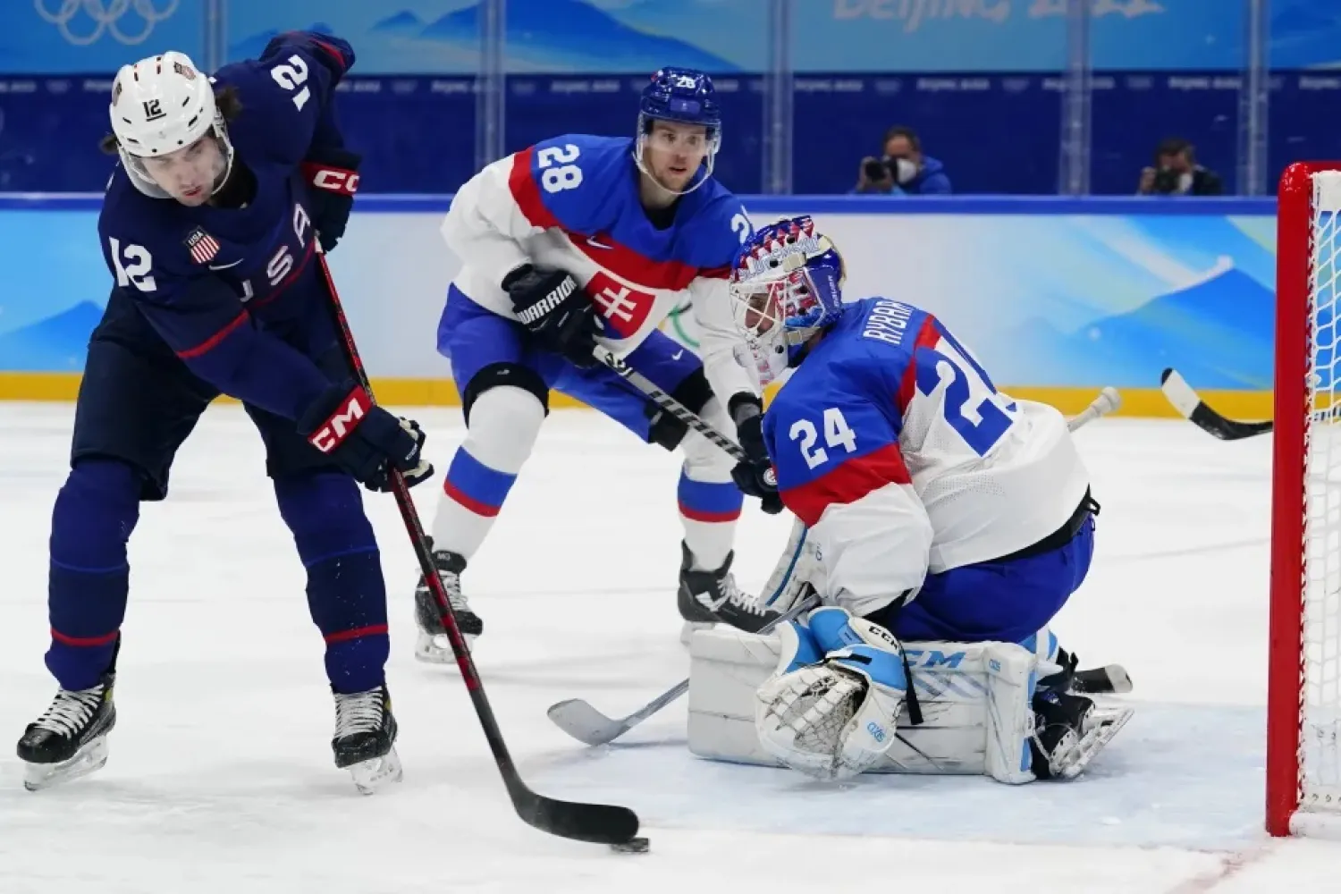 United States' Sam Hentges (12) scores a goal against Slovakia goalkeeper Patrik Rybar (24) during a men's quarterfinal hockey game at the 2022 Winter Olympics, Wednesday, Feb. 16, 2022, in Beijing. (AP)