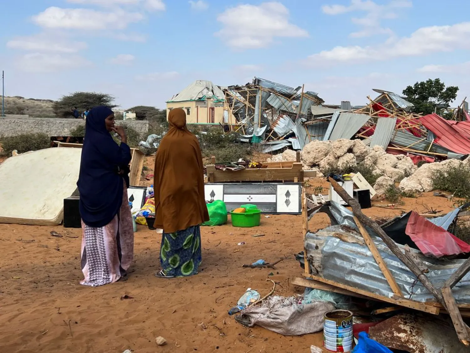 Somali women stand near their destroyed homes following an overnight attack in Mogadishu, Somalia February 16, 2022. (Reuters)