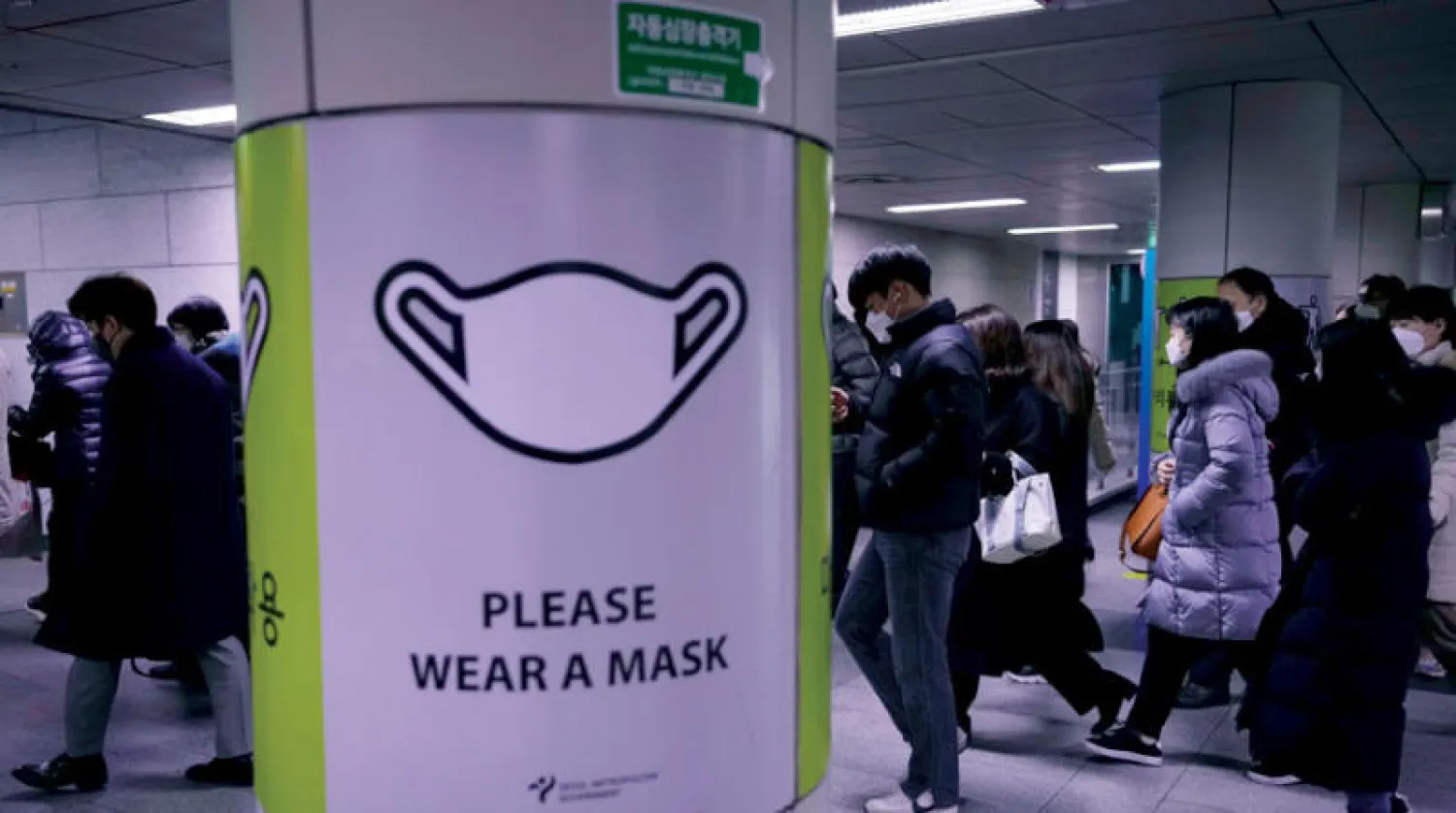 لافتة تحض على ارتداء الكمامة بمحطة قطار في سيول (أ.ب)