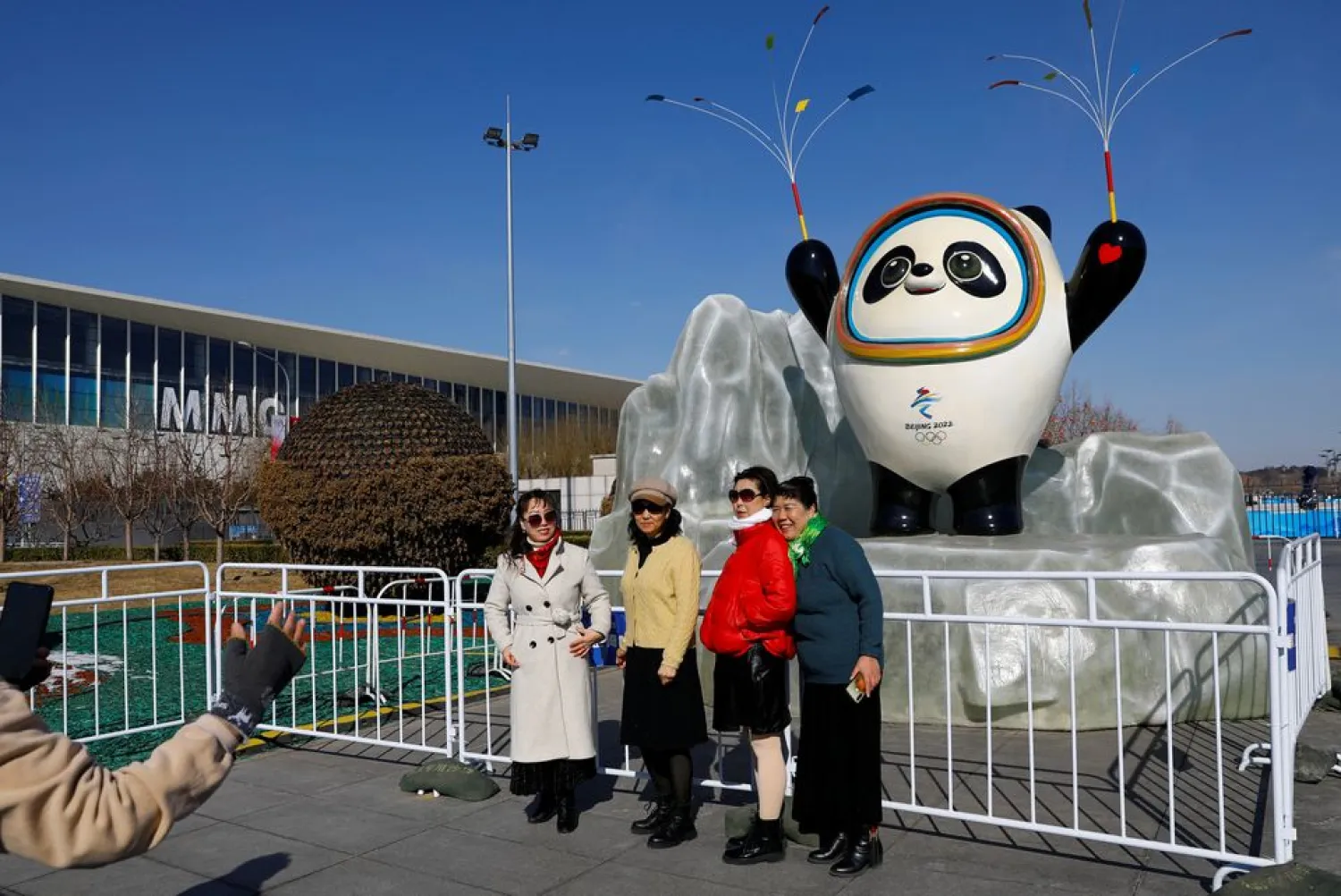 People pose for pictures near an installation of the Beijing 2022 Olympics mascot Bing Dwen Dwen, ahead of the closing ceremony of the Beijing 2022 Winter Olympics, in Beijing, China February 20, 2022. (Reuters)