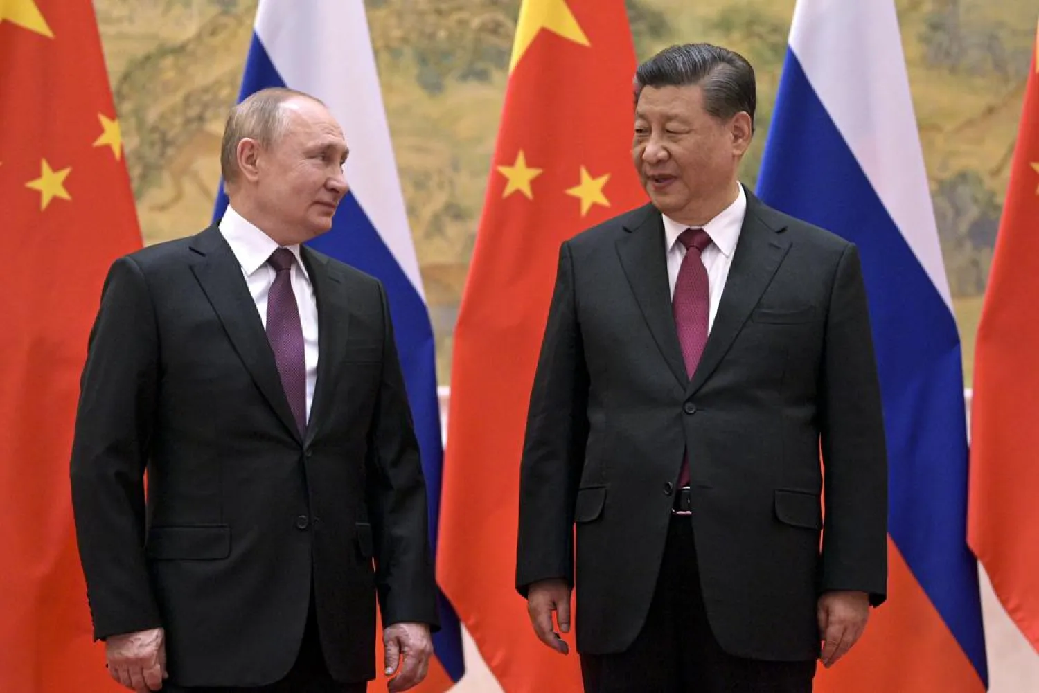 Chinese President Xi Jinping, right, and Russian President Vladimir Putin talk to each other during their meeting in Beijing, Friday, Feb. 4, 2022. (AP)