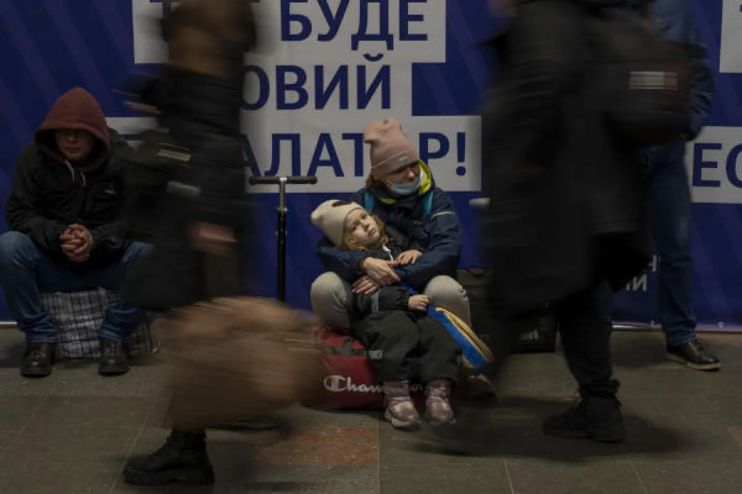 A woman with her daughter waits for a train as they try to leave at the Kyiv train station, Ukraine, Thursday, Feb. 24, 2022. AP