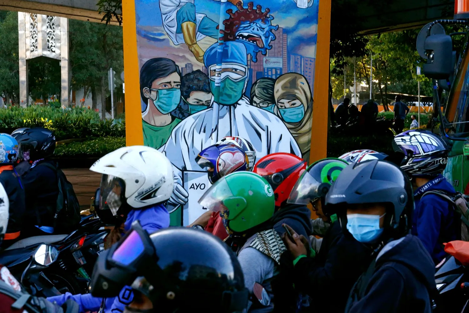  Motorcycle riders are seen near a mural promoting awareness of
the coronavirus disease (COVID-19) outbreak in Jakarta, Indonesia,
Dec. 1, 2020.
