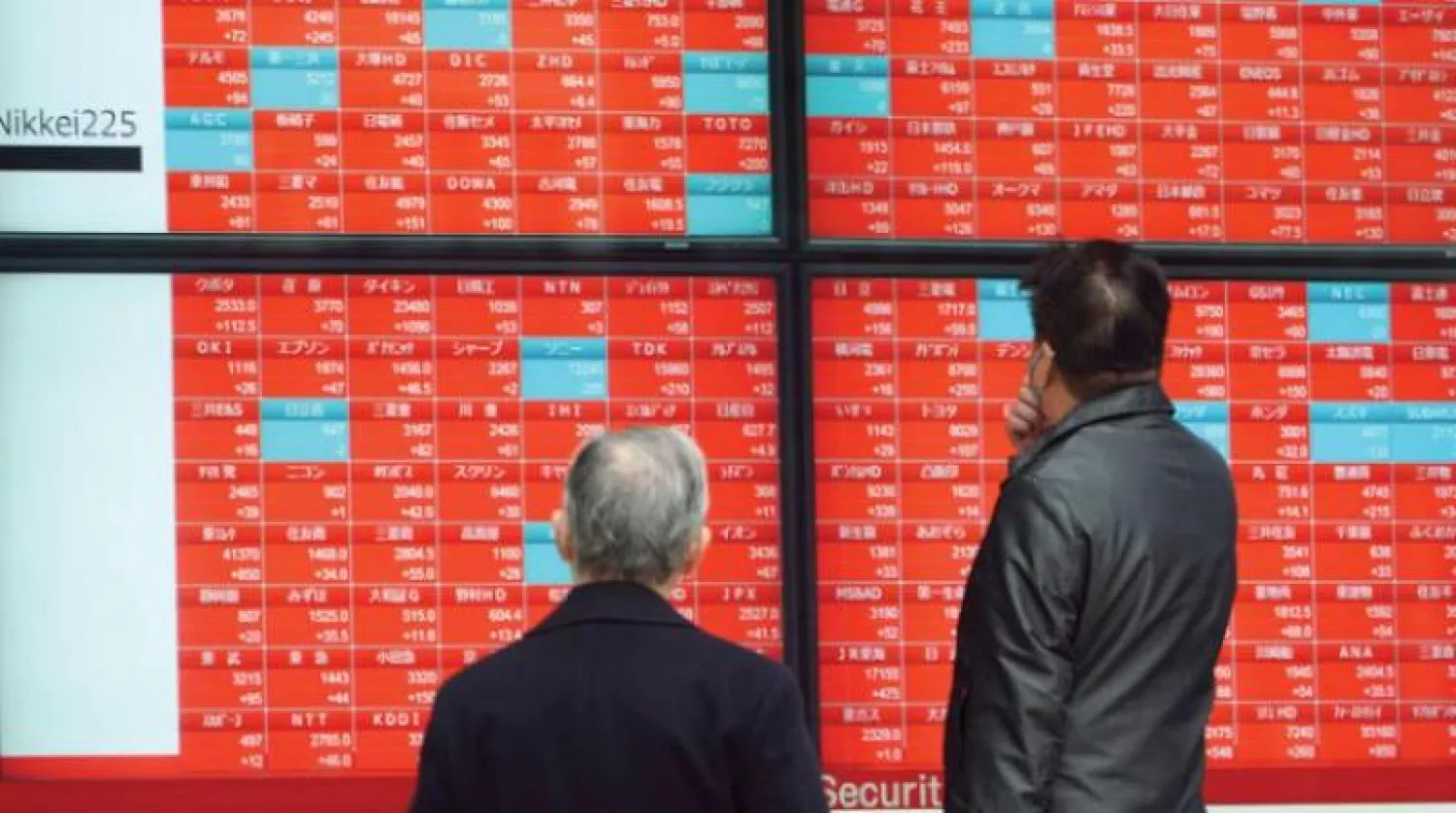 يابانيان يراقبان شاشة أسعار أسهم بورصة طوكيو (أرشيفية - أ.ب)