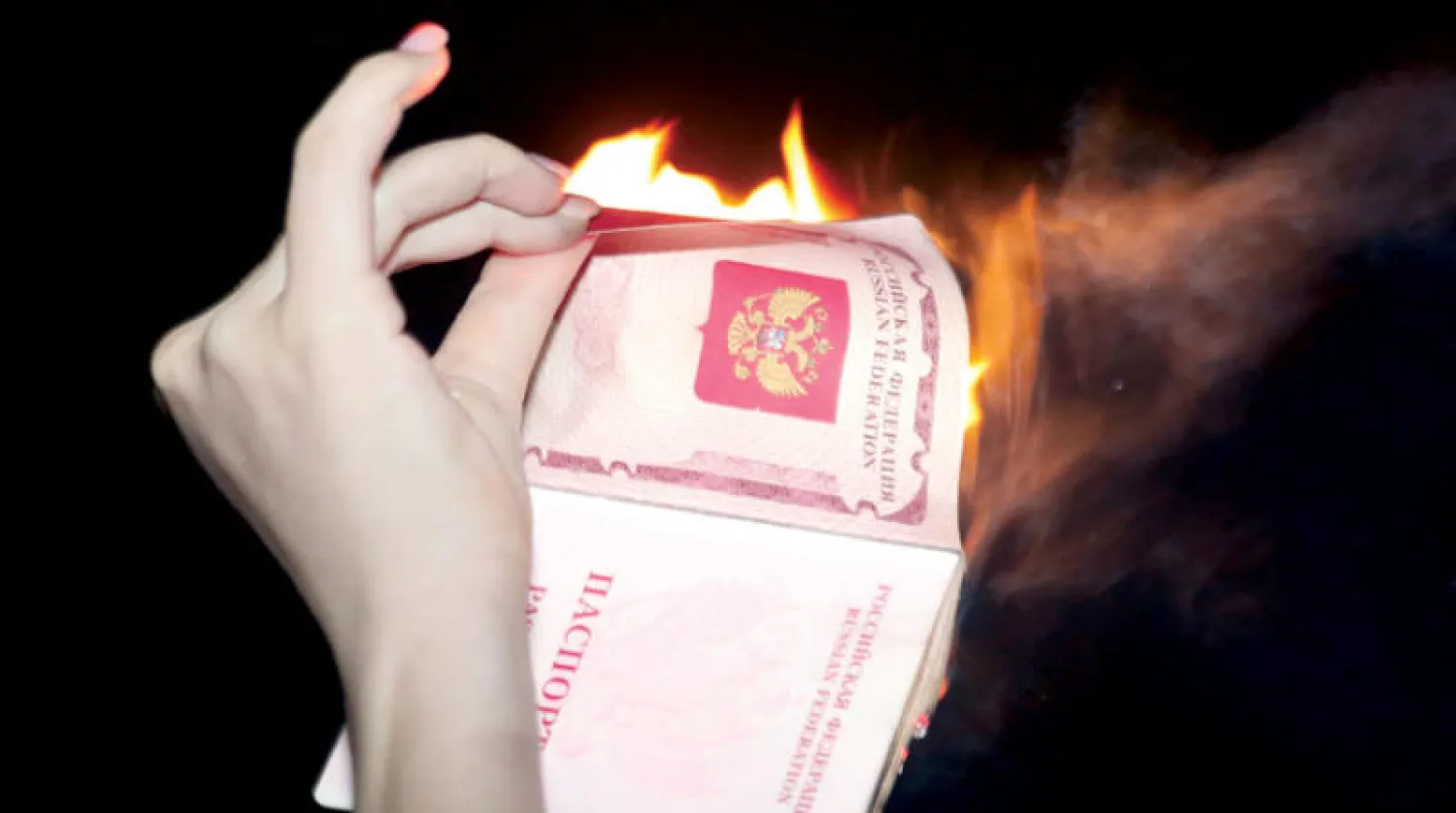روسية تحرق جواز سفرها خلال تظاهرة مؤيدة لأوكرانيا في تل أبيب أول من أمس (أ.ب)