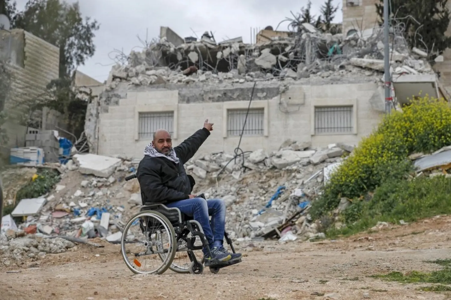 A Palestinian citizen points at his house which was demolished again by Israeli forces in the East Jerusalem neighborhood of Issawiya on March 1, 2021. (AFP)