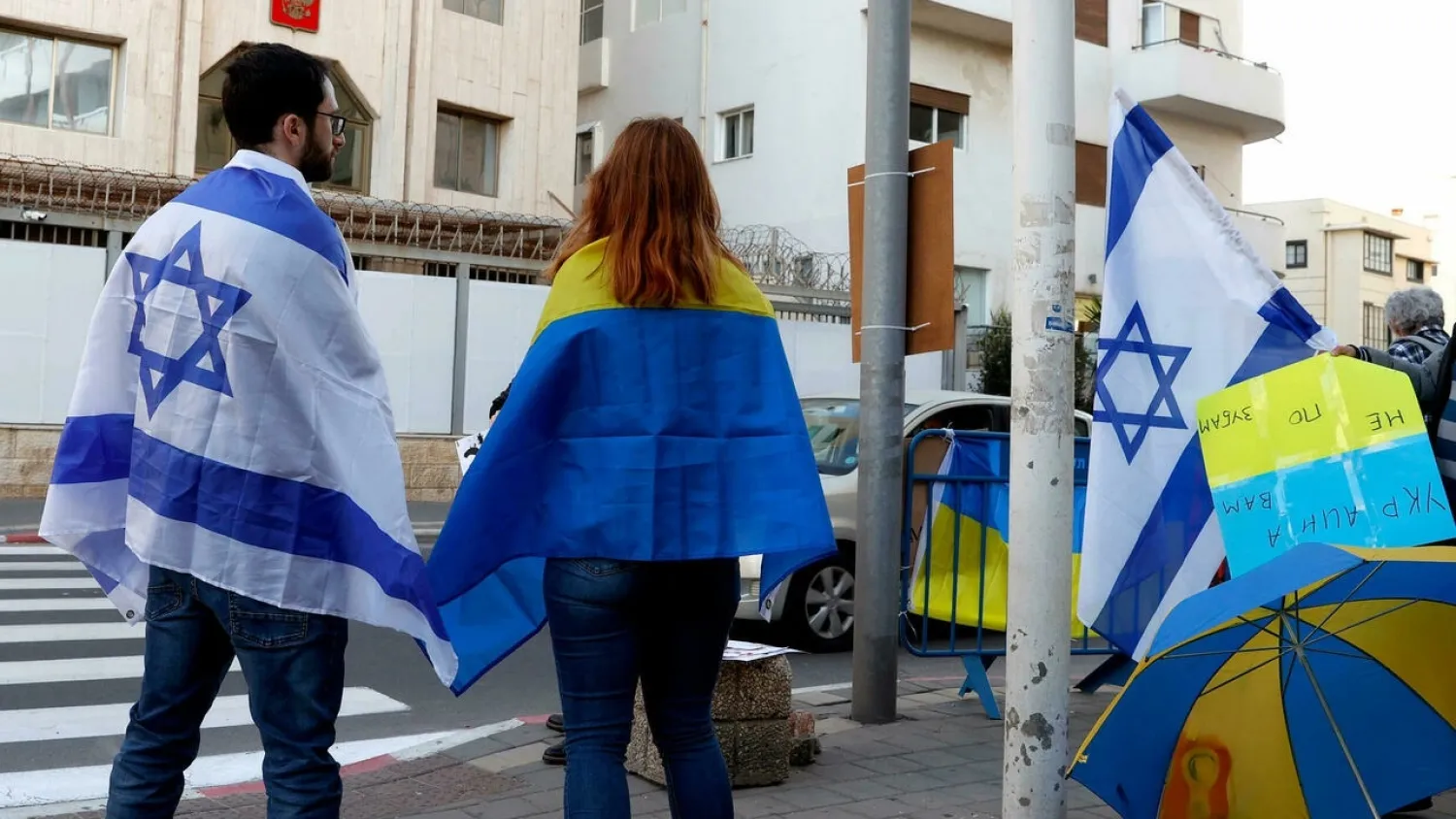 People clad in the Israeli and Ukrainian flags take part in a Tel Aviv protest against Russia's attack on Ukraine. (AFP)