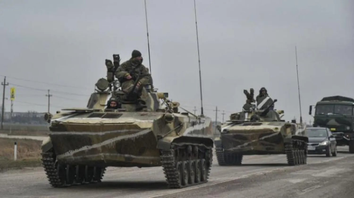 جنود روس على ظهر عربات برمائية قتالية يتقدمون من شبه جزيرة القرم نحو أوكرانيا  (إ.ب.أ)