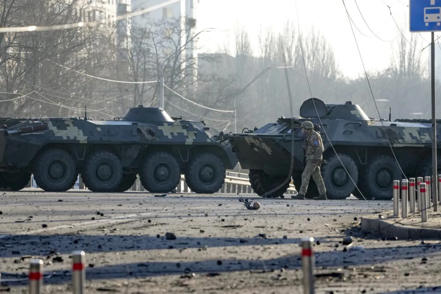 A soldier walks along Ukrainian armored vehicles blocking a street in Kyiv, Ukraine, Saturday, Feb. 26, 2022. (AP)