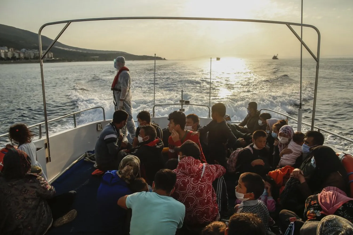 Migrants sit on a Turkish coast guard vessel after they were pulled off life rafts, during a rescue operation in the Aegean Sea, between Turkey and Greece, Saturday, Sept. 12, 2020.  (AP Photo/Emrah Gurel)
