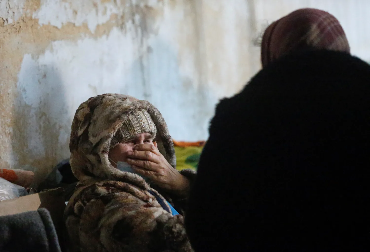عجوز تبكي خوفاً من وقع صوت انفجارات القذائف في ملجأ للقنابل في مستوطنة ميكولايفكا بمنطقة دونيتسك (رويترز)