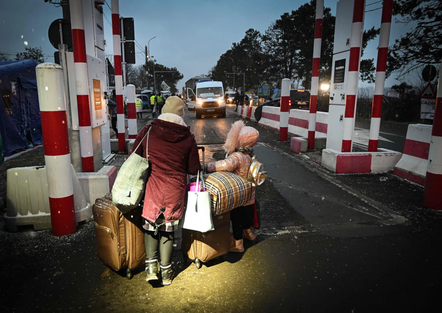 أم أوكرانية وطفلها يسيران عند نقطة سيريت الحدودية (أ.ف.ب)