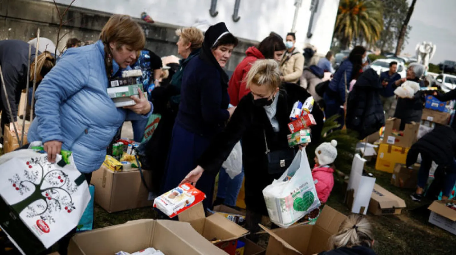 متطوعون في روما يجمعون مساعدات إنسانية قبل إرسالها إلى أوكرانيا أمس (رويترز)